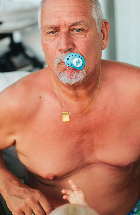 ima169888 Senior man with pacifier in mouth